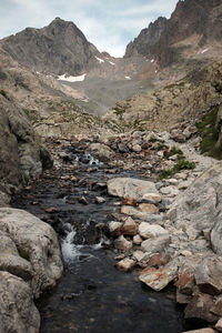 Scenic view of stream amidst rocks against sky