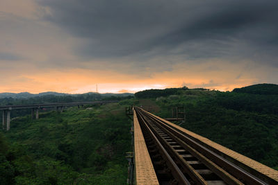 Railroad tracks against sky during sunset