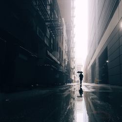 Man with umbrella walking down city street