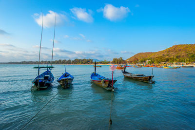 Boats moored in sea against sky