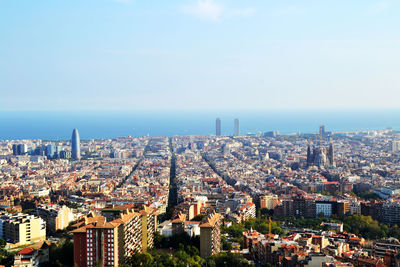 High angle view of city by sea against sky