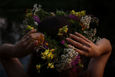 Midsection of woman holding purple flowering plant