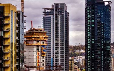 Buildings in city against cloudy sky