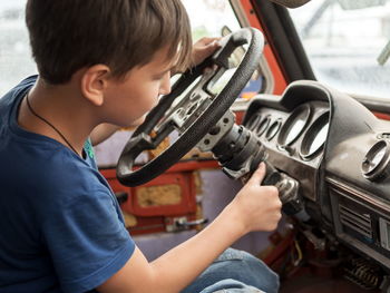 Close-up of boy holding steering wheel