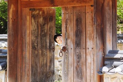 Portrait of boy looking through doorway