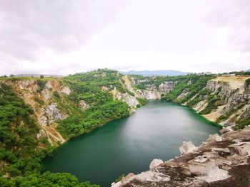 Scenic view of river against cloudy sky