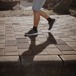 Low section of woman walking on street