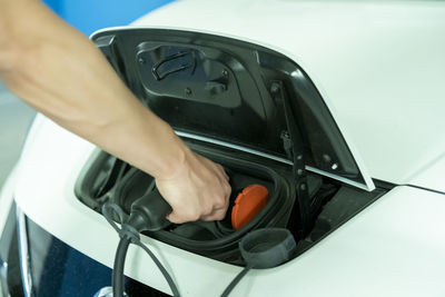 Young man charging his non-polluting electric vehicle