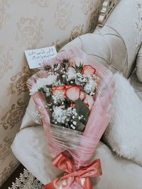 High angle view of woman holding white flower at home