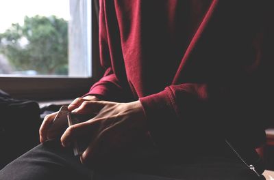 Close-up of hands against window