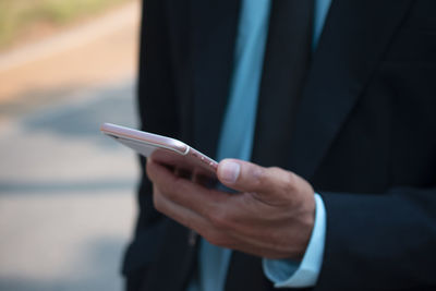 Midsection of businessman using mobile phone