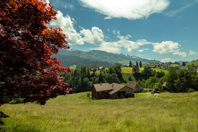 Houses on countryside landscape against sky