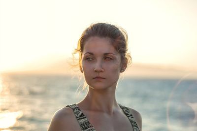 Portrait of young woman standing against sea