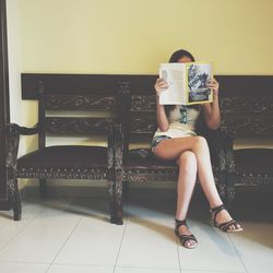 Full length of woman standing on bench