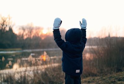 Rear view of a young boy by lake