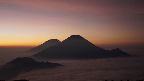 Scenic view of silhouette mountains against sky during sunset