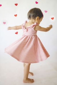 Portrait of cute girl standing against white background