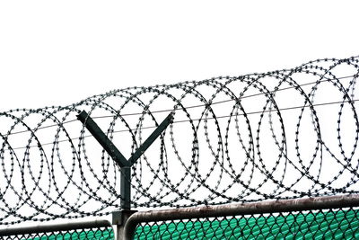 Low angle view of barbed wire against clear sky