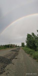 Scenic view of rainbow over road against sky