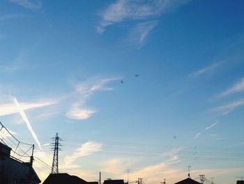 Low angle view of electricity pylon against blue sky