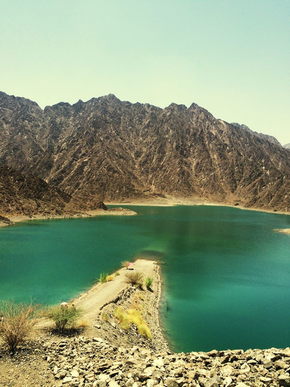 water, tranquil scene, tranquility, scenics, blue, mountain, beauty in nature, clear sky, sea, nature, beach, lake, copy space, shore, idyllic, coastline, sky, day, calm, mountain range