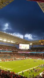 People playing soccer on field against sky