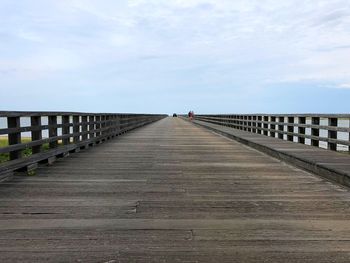 Footbridge over pier against sky