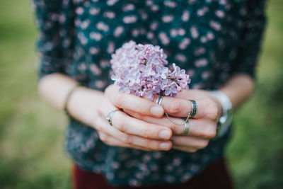 Midsection of woman holding purple flowers