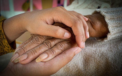 Midsection of couple holding hands