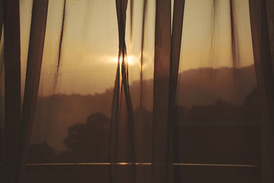 Close-up of curtain against sky during sunset