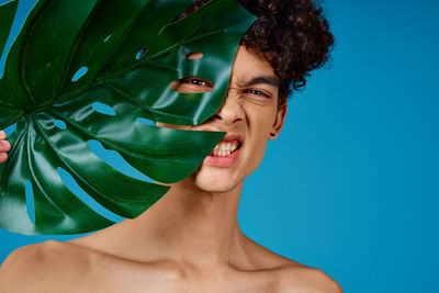 Portrait of smiling young woman against blue background