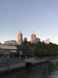 River and buildings against clear sky