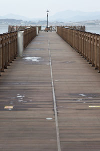 Surface level of pier over sea against sky