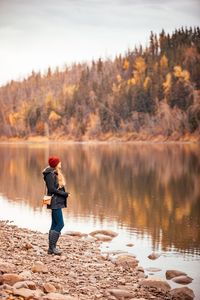 Man standing by lake against sky