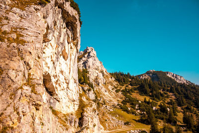 Low angle view of rock formation against clear blue sky