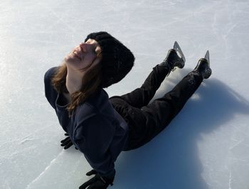 High angle view of woman with eyes closed lying on frozen lake