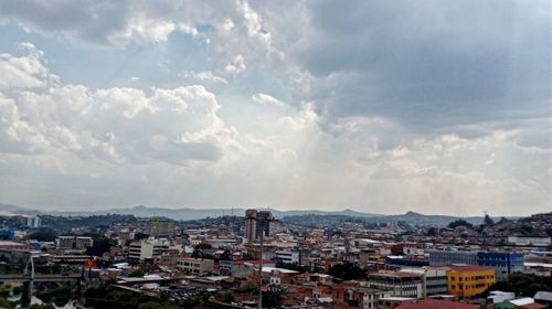 View of cityscape against cloudy sky