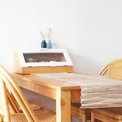 Stack of empty chairs and table against wall