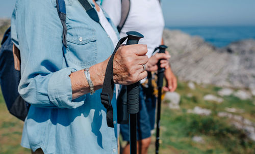 Midsection of man holding umbrella while standing on land