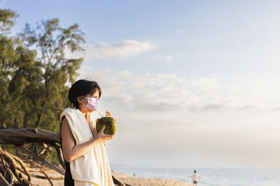 Woman on beach wearing face mask