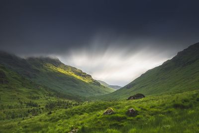 Scenic view of field and mountains against sky