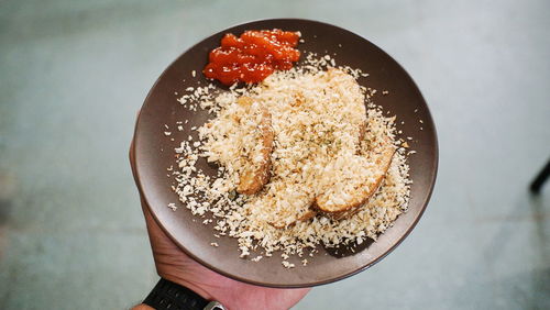 Cropped hand of person holding food in plate