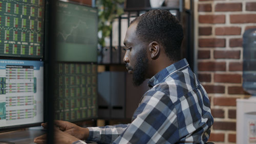 Side view of stock trader working at office