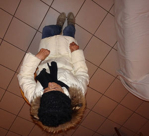 Low section of man lying on tiled floor