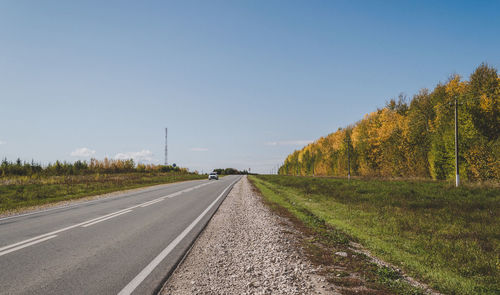 Road amidst trees against clear sky