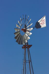 Low angle view of traditional windmill against clear blue sky