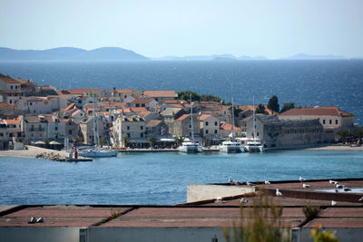 Boats in sea with buildings in background