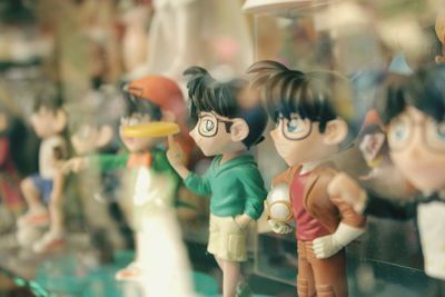 Figurines for sale at store seen through glass