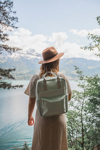 Rear view of woman looking at lake against sky