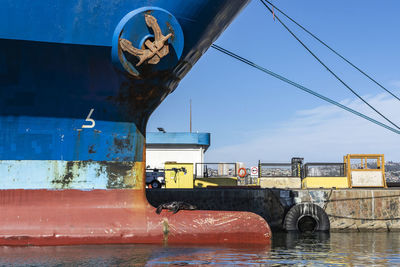 Metallic structure by boat against blue sky